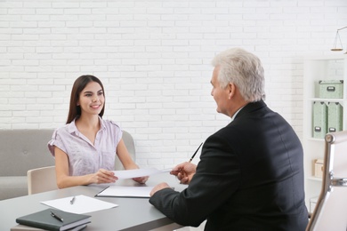 Photo of Young woman having meeting with lawyer in office
