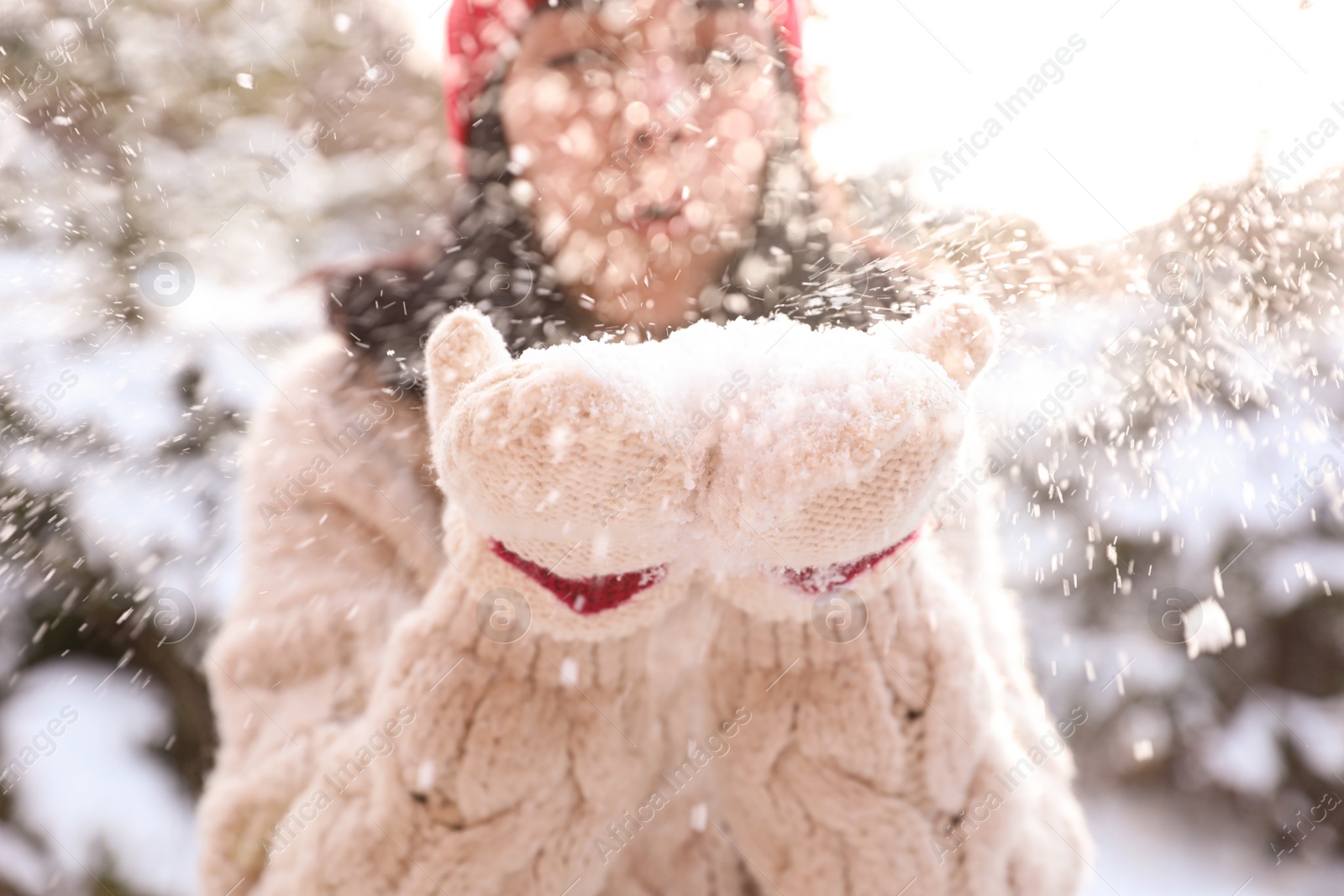 Photo of Young woman blowing snow outdoors, closeup. Winter vacation