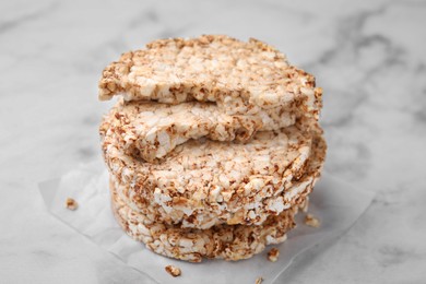 Photo of Stack of crunchy buckwheat cakes on white marble table, closeup