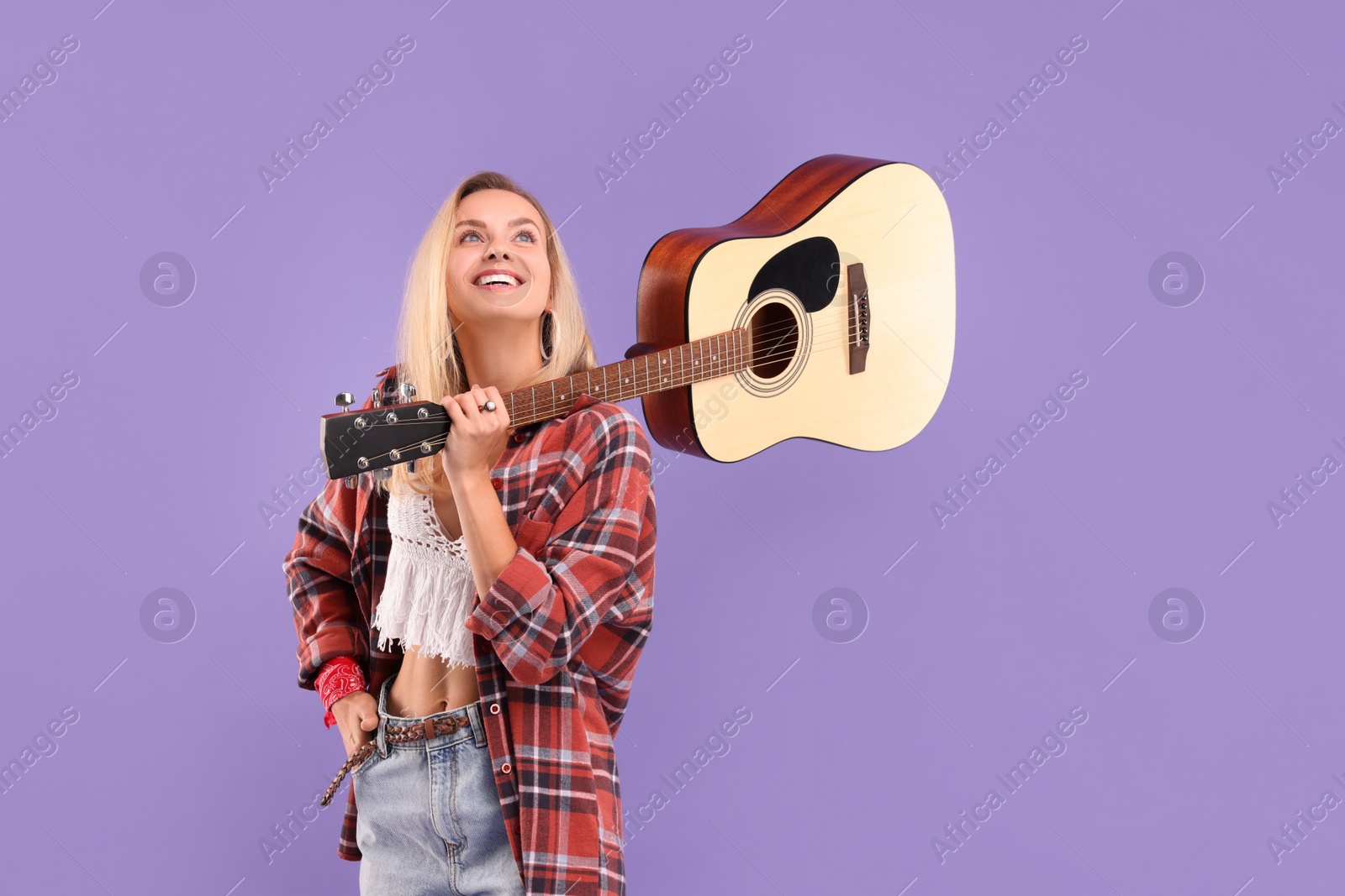 Photo of Happy hippie woman with guitar on purple background