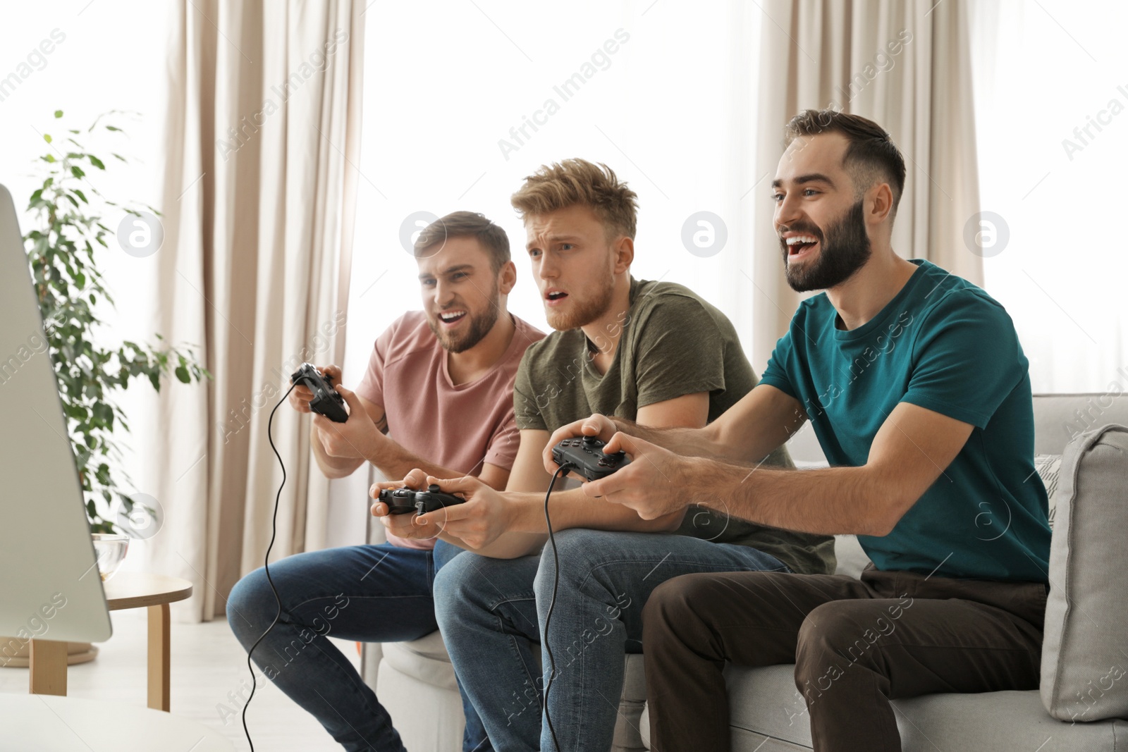 Photo of Emotional friends playing video games at home