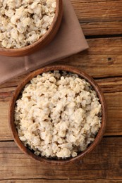 Photo of Tasty boiled oatmeal on wooden table, flat lay