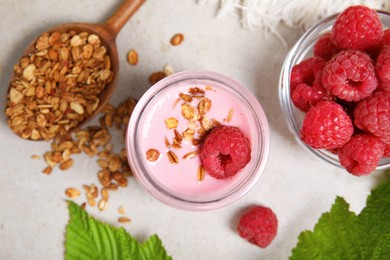 Photo of Tasty raspberry smoothie with granola in glass jar and fresh berries on light table, flat lay