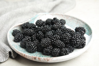 Photo of Plate of tasty ripe blackberries on light table