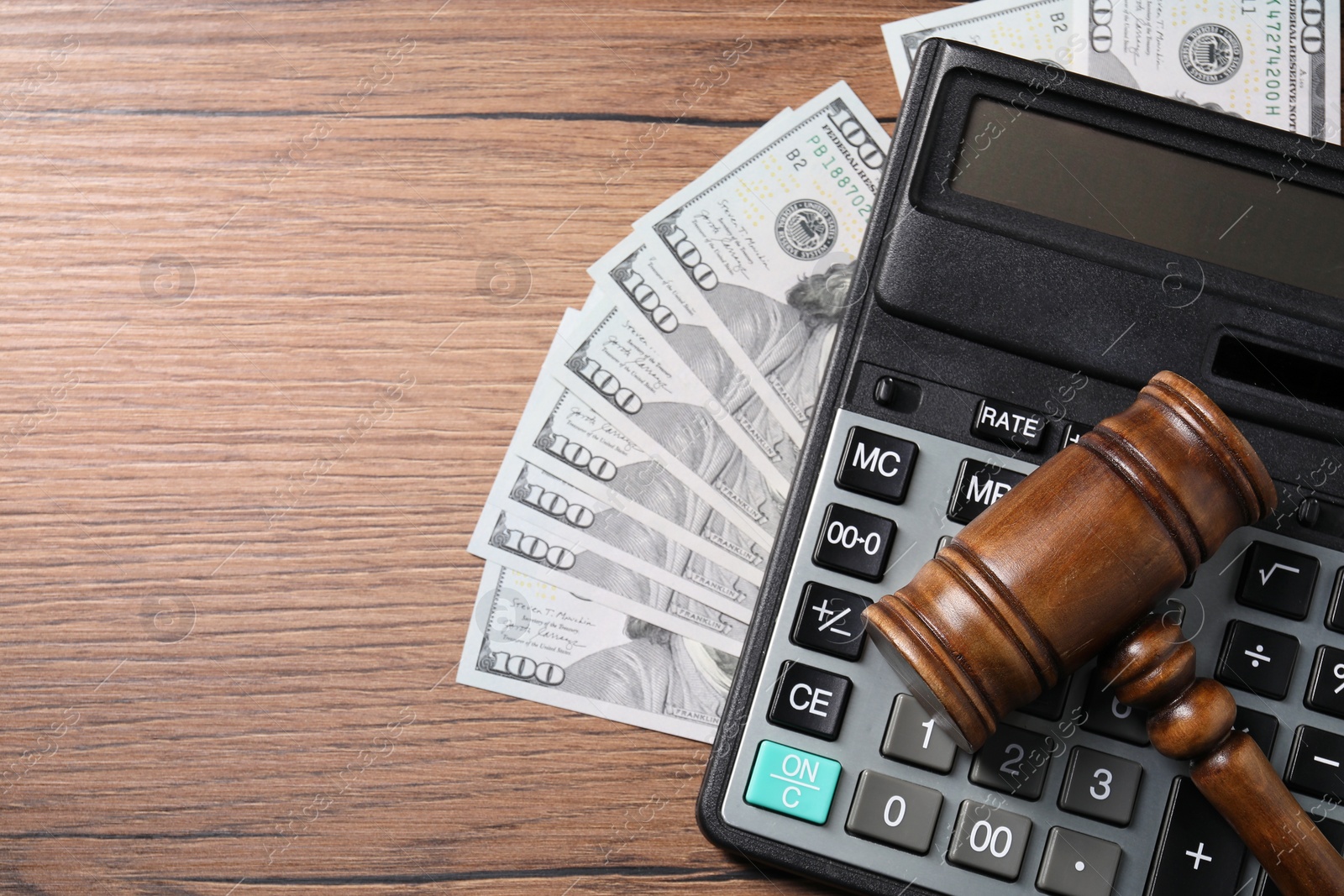 Photo of Tax law. Gavel, dollar banknotes and calculator on wooden table, top view. Space for text