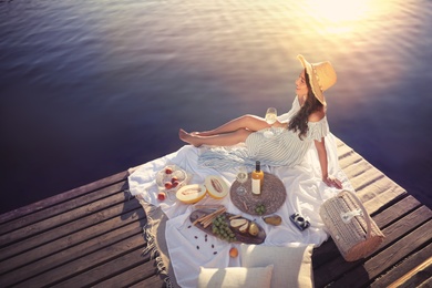 Photo of Young woman spending time on pier at picnic