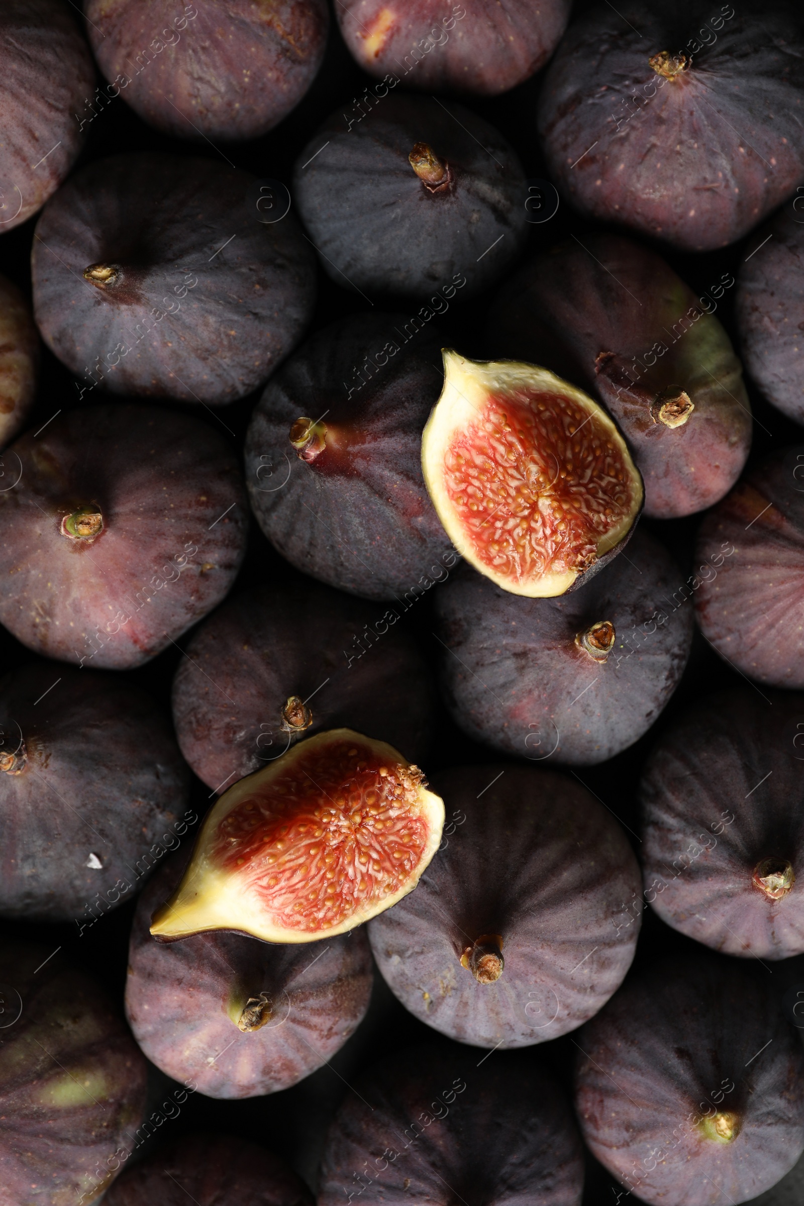 Photo of Tasty cut fig on whole ripe fruits, top view