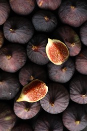 Tasty cut fig on whole ripe fruits, top view