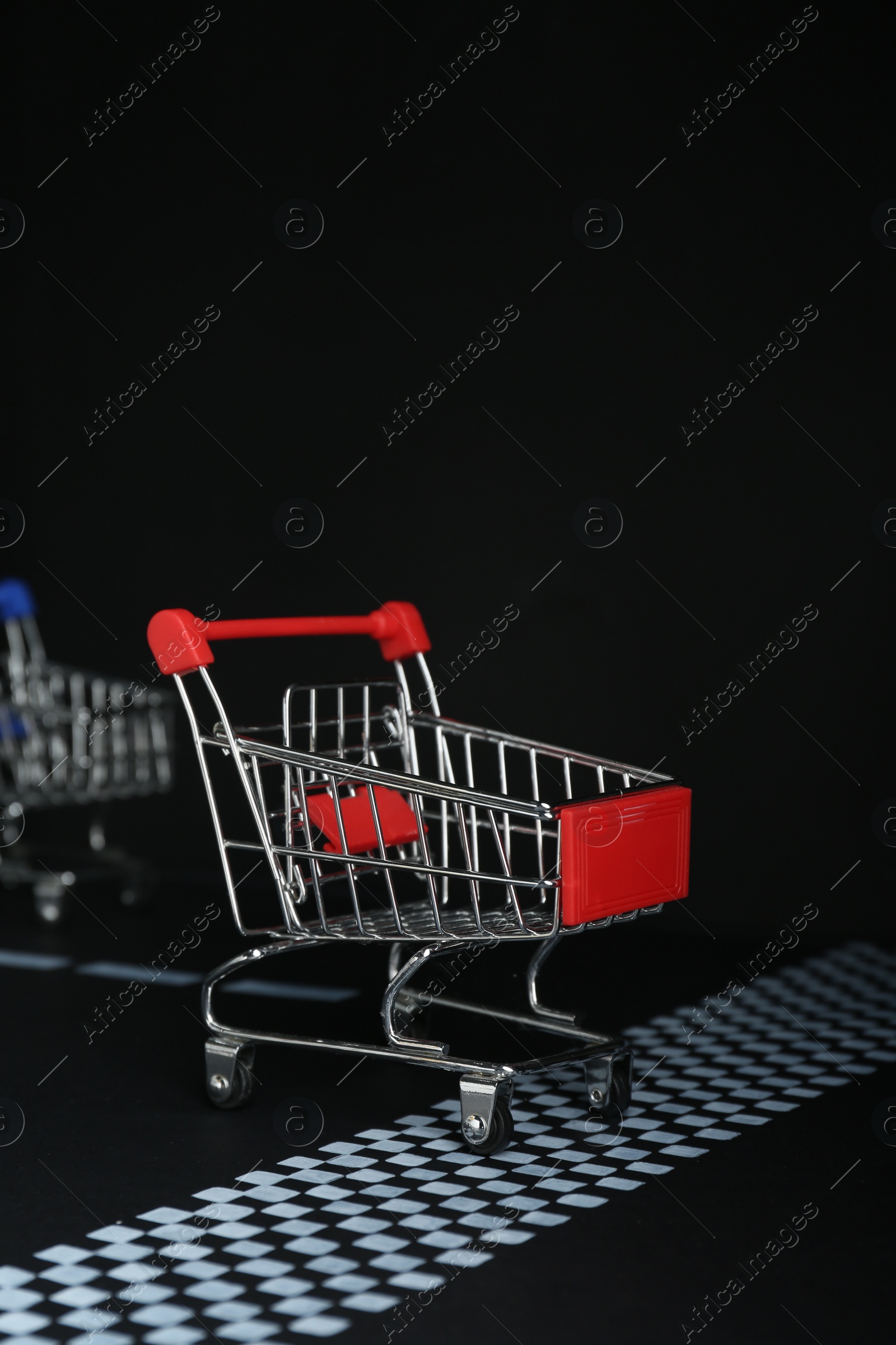 Photo of Competition concept. Red shopping cart crossing finish line