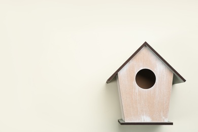 Beautiful bird house on beige background, top view. Space for text