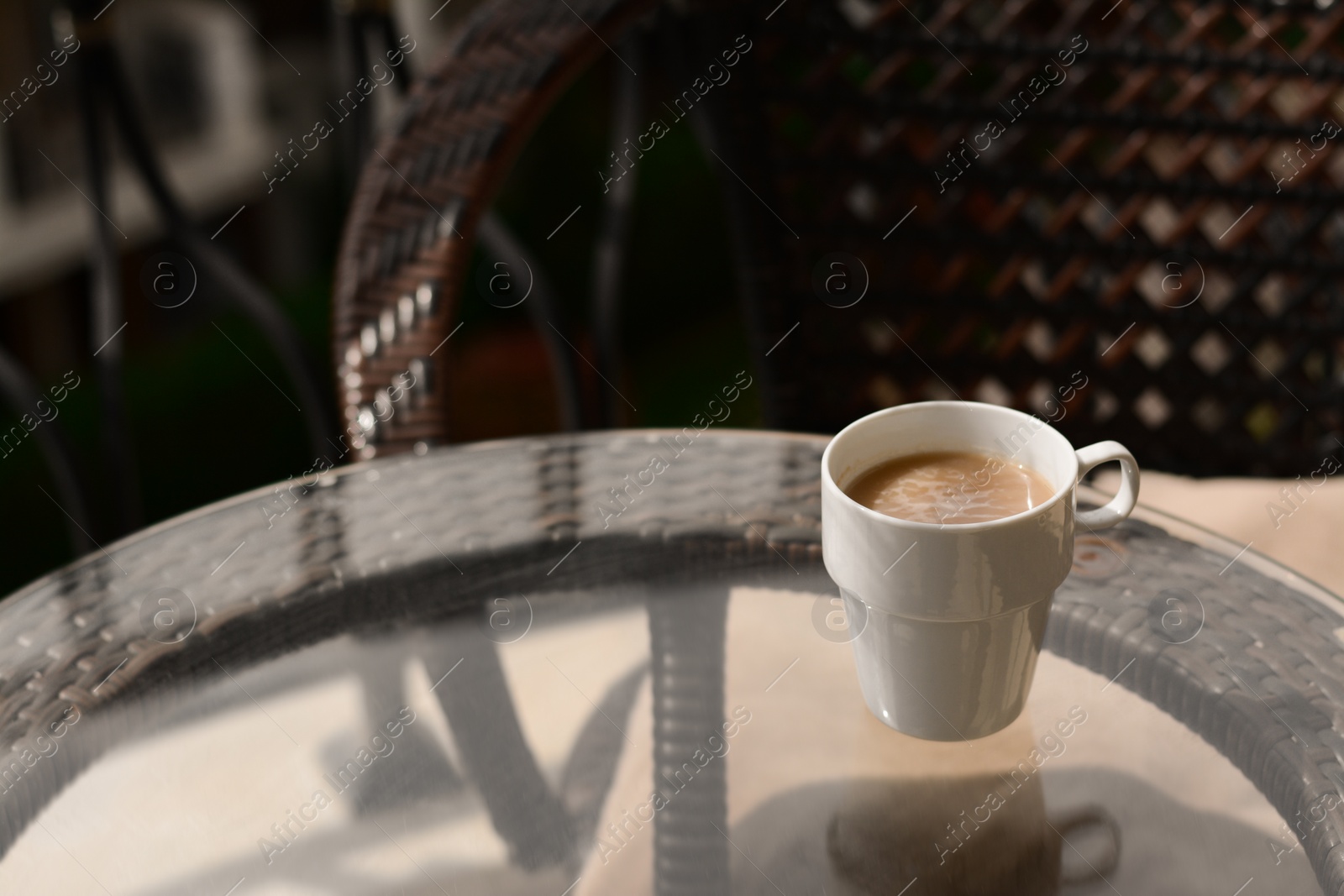 Photo of Ceramic cup of aromatic coffee on glass table outdoors, space for text. Good morning