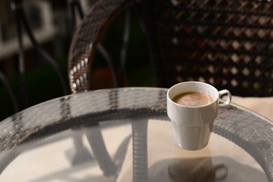 Ceramic cup of aromatic coffee on glass table outdoors, space for text. Good morning