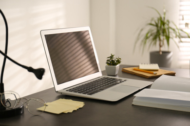 Photo of Modern laptop on office table. Stylish workplace