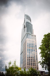 Photo of Beautiful building with many windows on cloudy day in city, low angle view