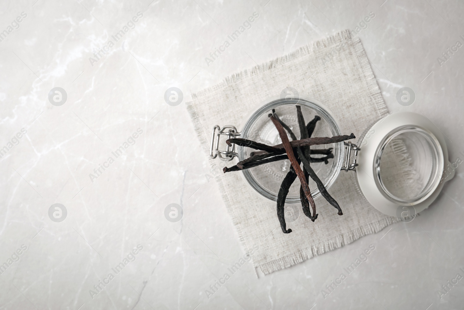 Photo of Jar with aromatic vanilla sticks on grey background