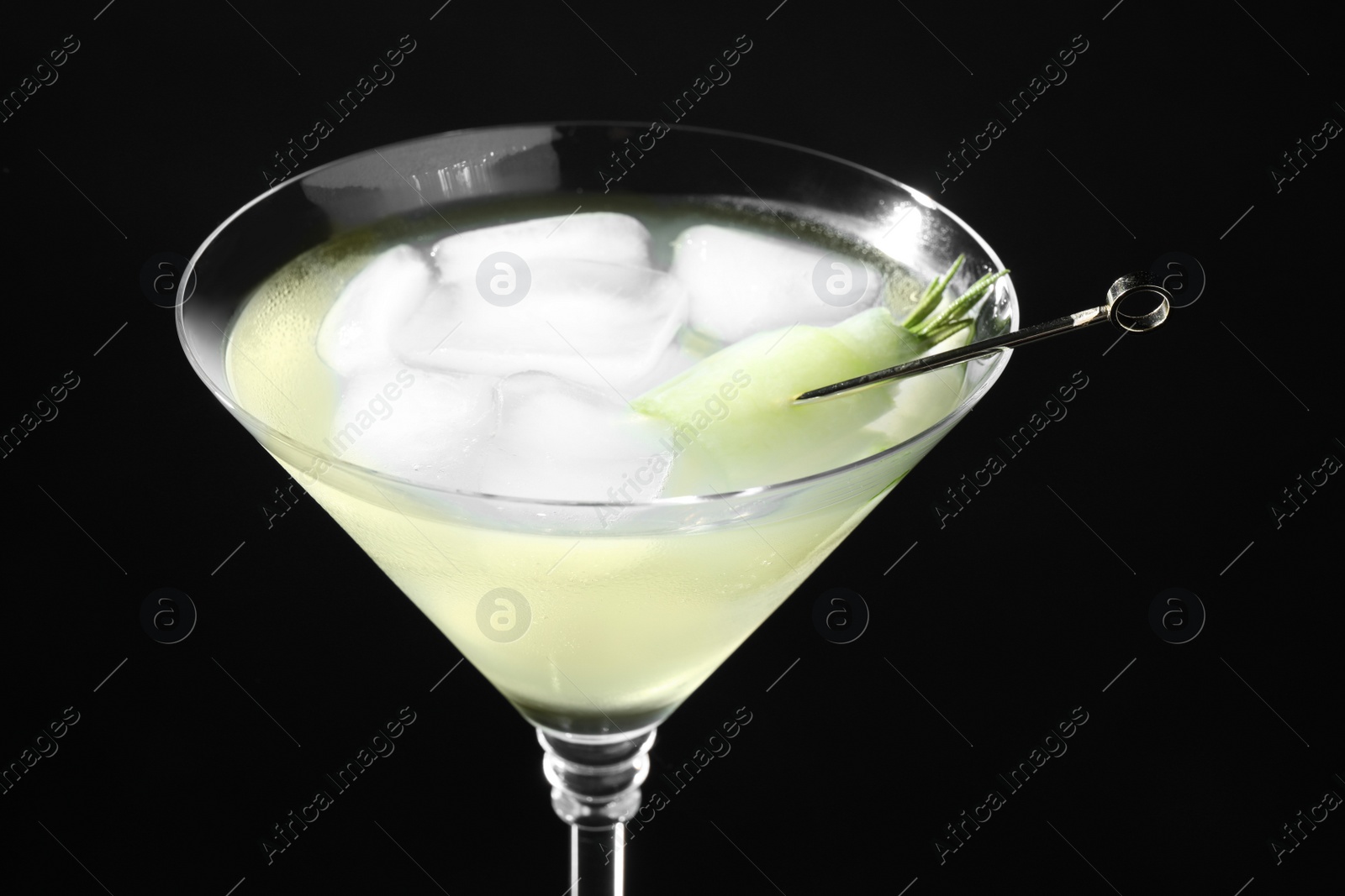Photo of Glass of delicious cucumber martini with ice on dark background, closeup