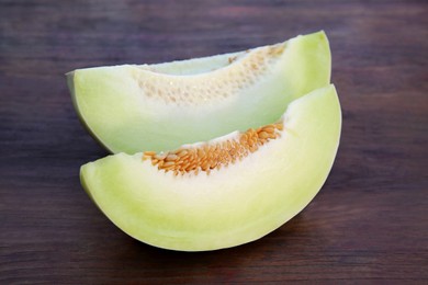 Photo of Cut tasty ripe melon on wooden table