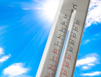 Image of Weather thermometer with high temperature outdoors on hot sunny day. Heat stroke warning