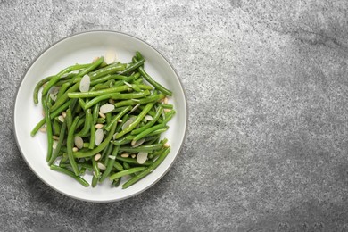 Photo of Bowl of tasty salad with green beans on grey table, top view. Space for text