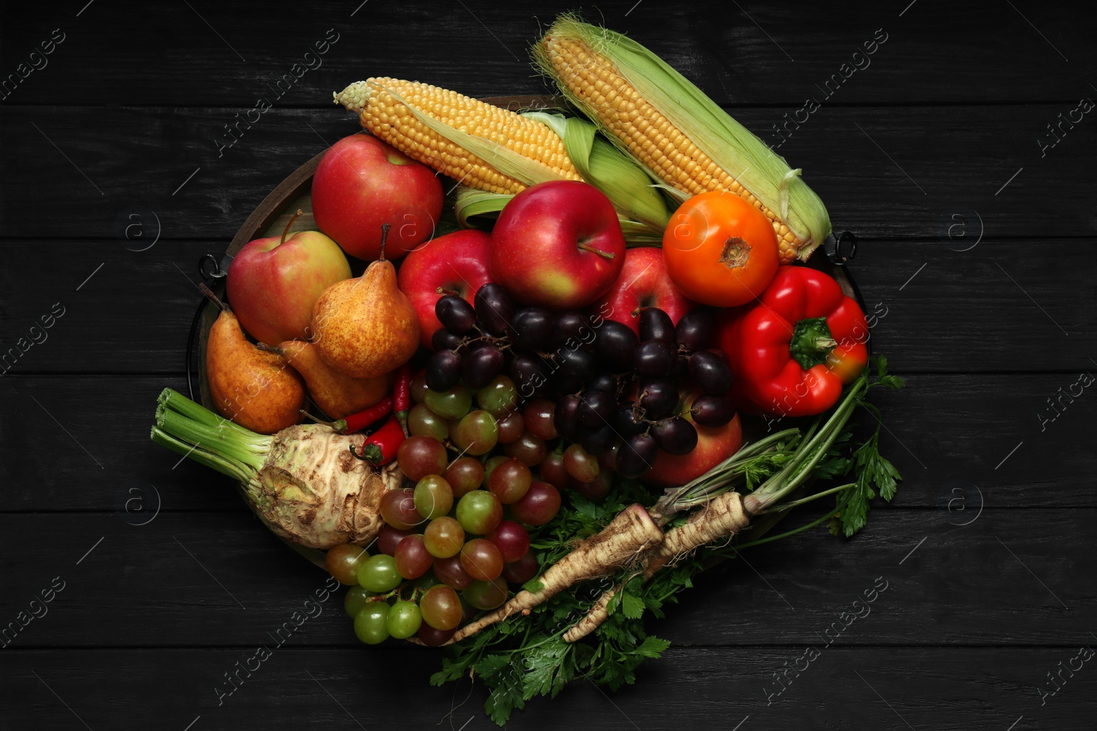 Photo of Different fresh vegetables and fruits on black wooden table, top view. Farmer harvesting