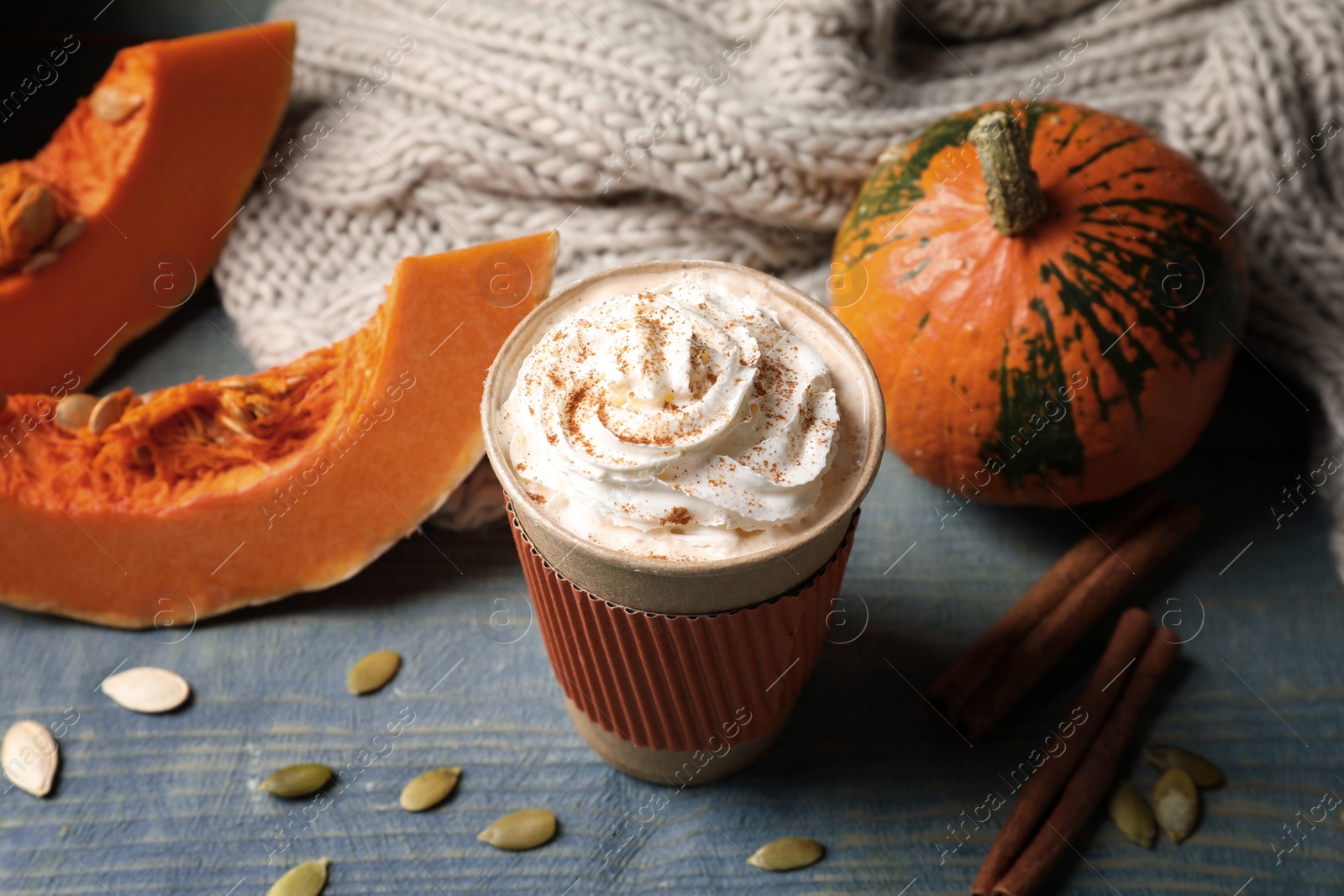 Photo of Cup with tasty pumpkin spice latte on wooden table
