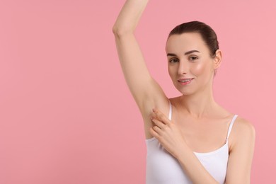 Photo of Beautiful woman showing armpit with smooth clean skin on pink background, space for text