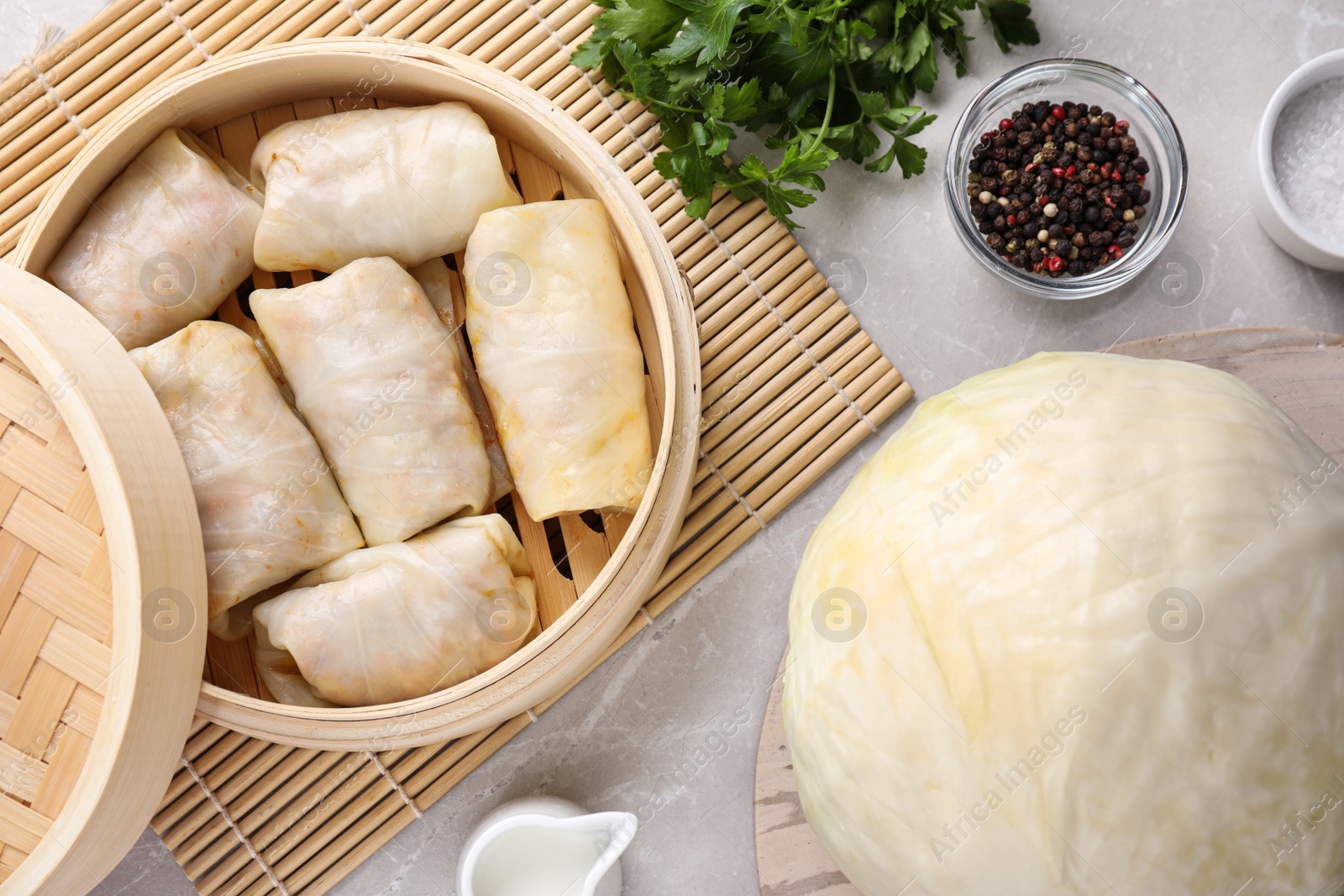 Photo of Delicious cabbage rolls served on light grey marble table, flat lay