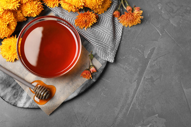 Flat lay composition with organic honey on dark grey table. Space for text