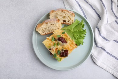 Photo of Tasty sausage casserole with green onion and bread on light grey table, top view