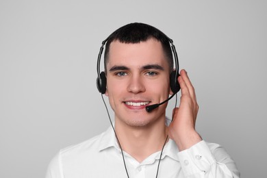 Photo of Hotline operator with headset on light grey background