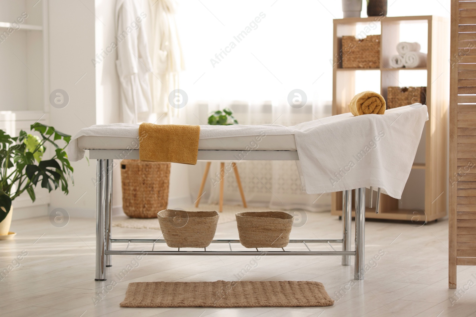 Photo of Comfortable massage table with clean towels in spa center