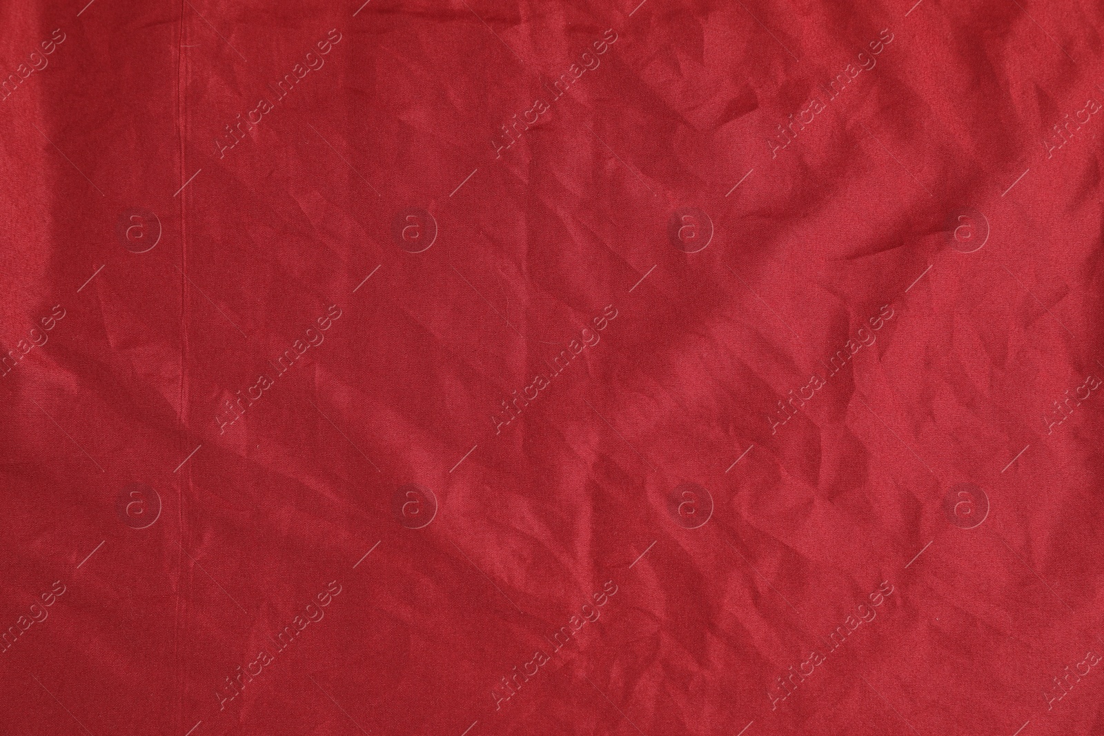 Photo of Crumpled dark red fabric as background, top view