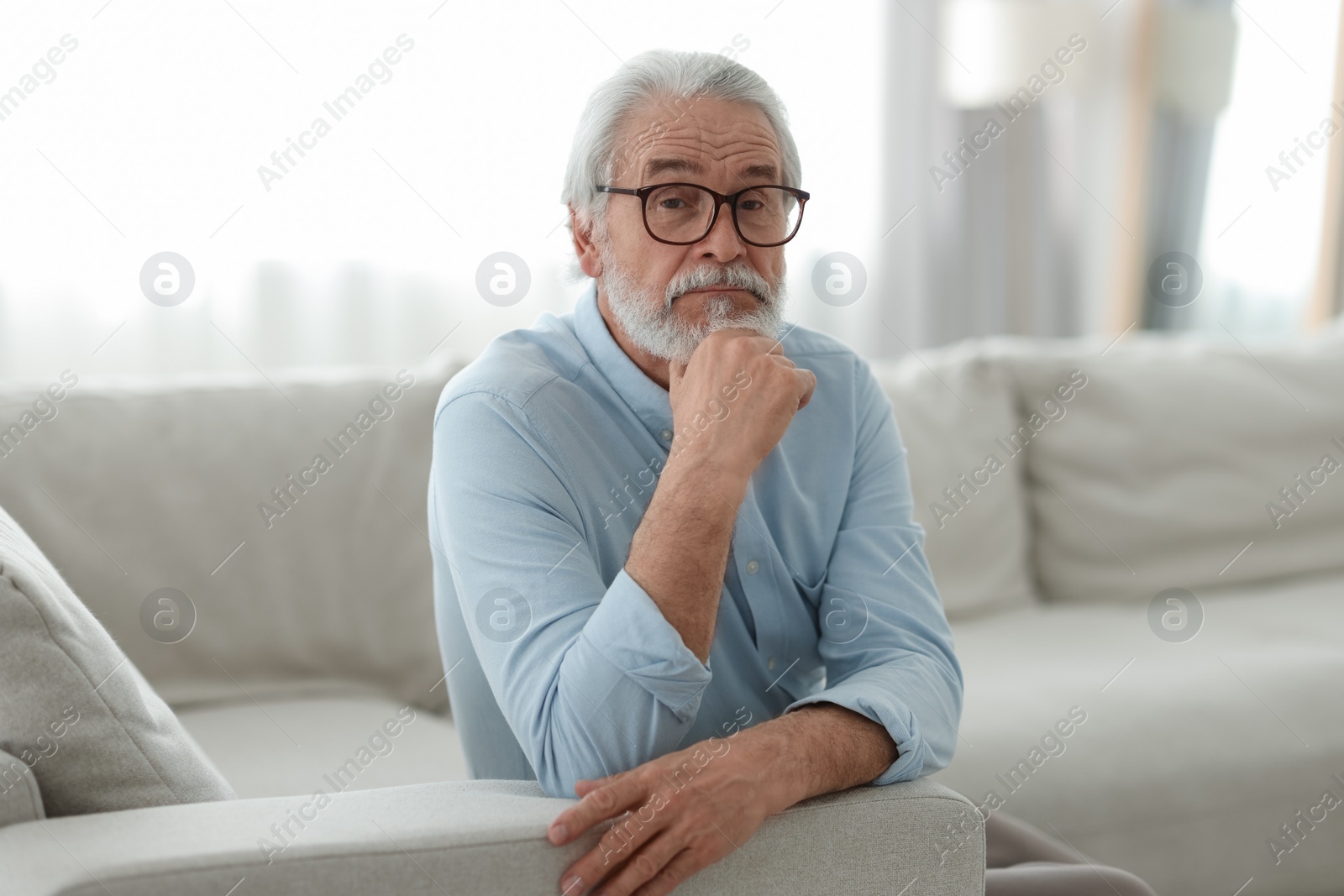 Photo of Portrait of grandpa with stylish glasses on sofa indoors