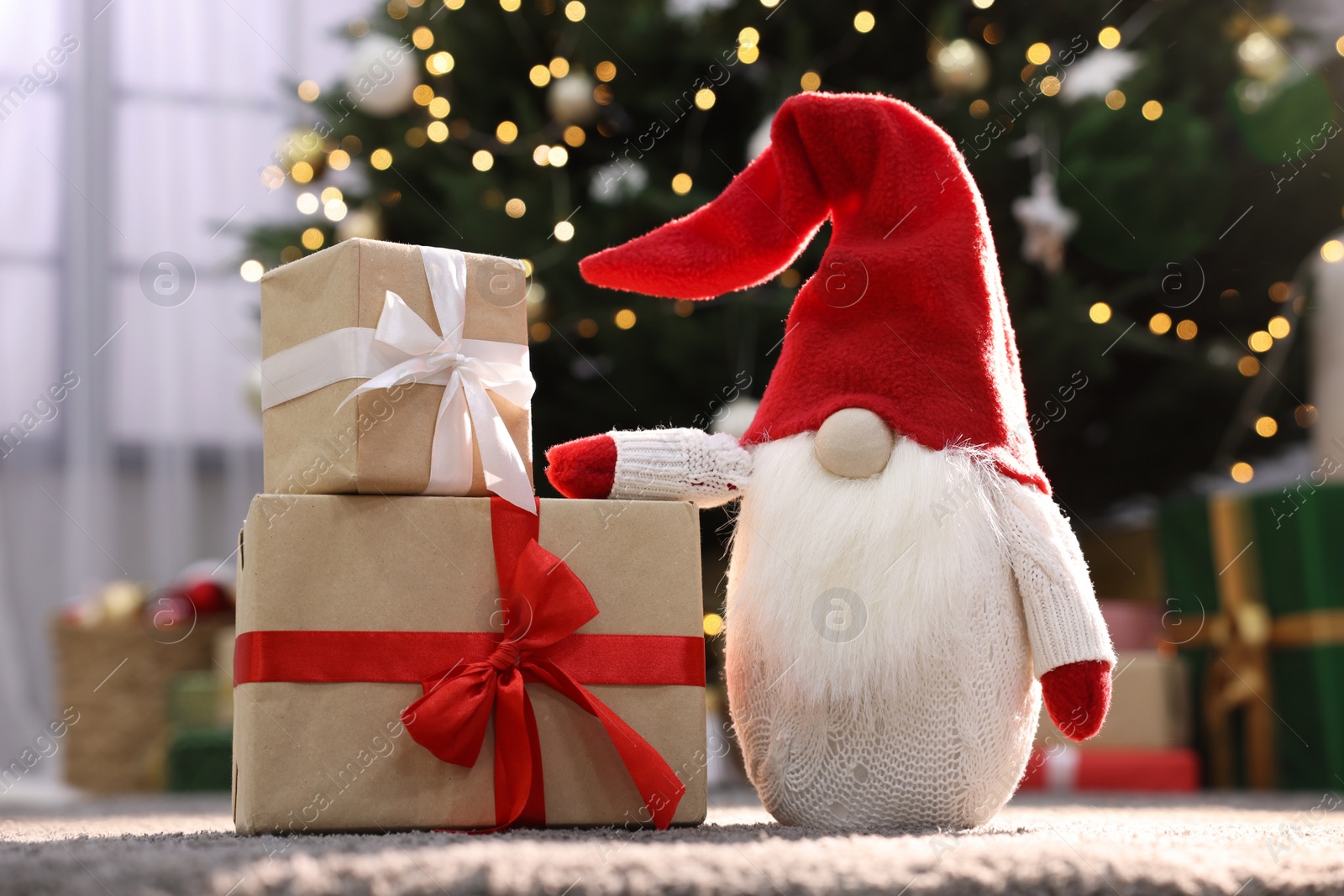 Photo of Beautiful gift boxes and Christmas gnome on carpet indoors