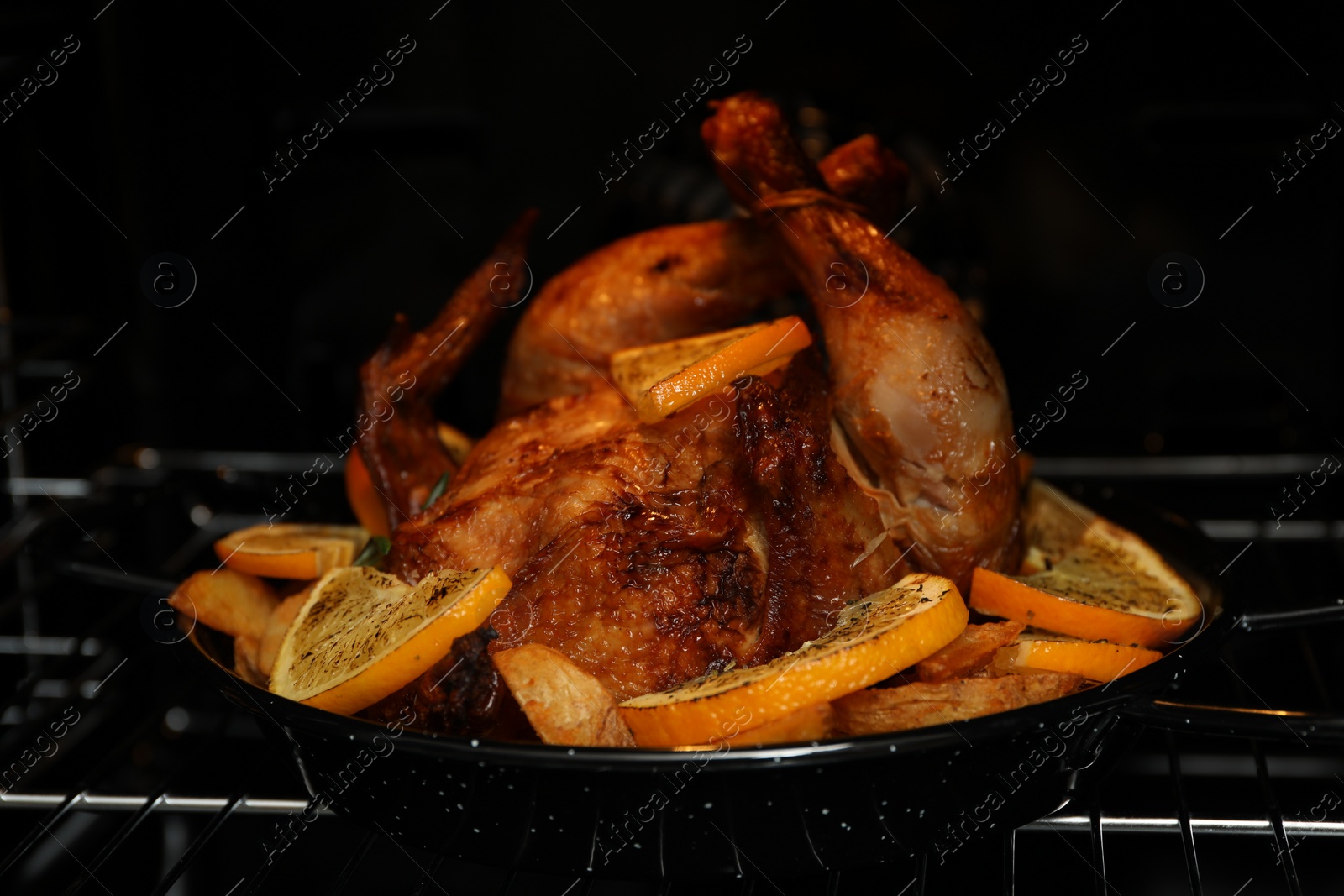 Photo of Chicken with orange slices baking in oven