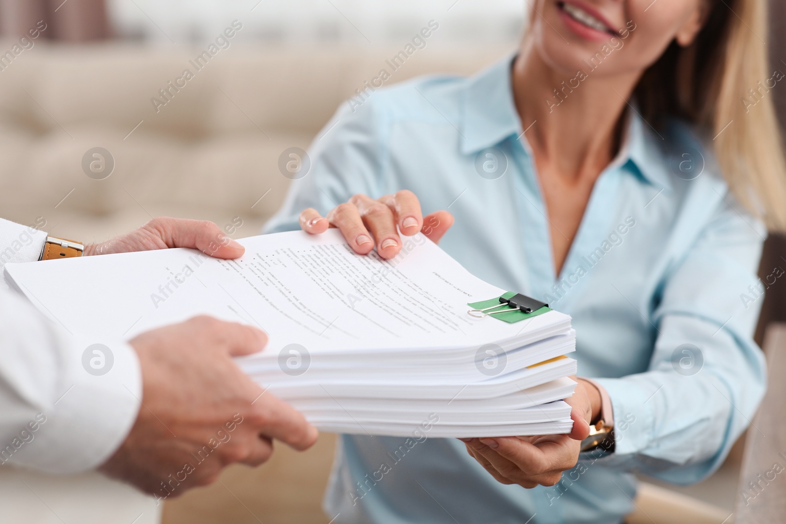 Photo of Woman giving documents to colleague in office, closeup