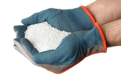 Photo of Man holding ammonium nitrate pellets on white background, closeup. Mineral fertilizer