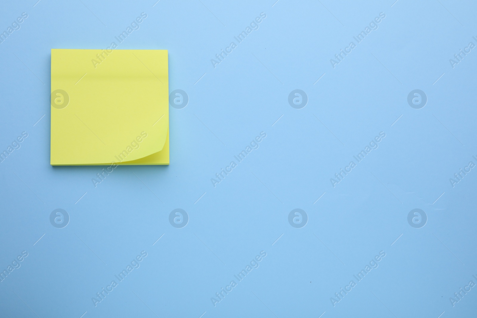 Photo of Paper note on light blue background, top view. Space for text