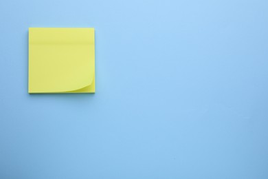 Photo of Paper note on light blue background, top view. Space for text
