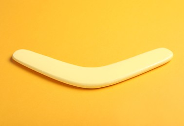 Photo of Wooden boomerang on yellow background. Outdoor activity