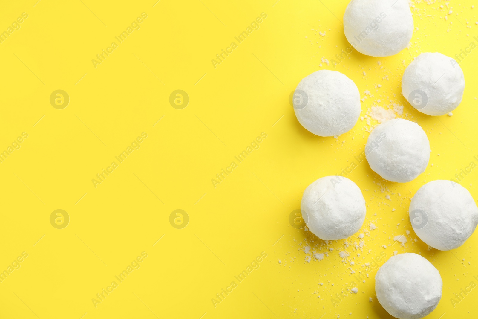 Photo of Snowballs on yellow background, flat lay. Space for text