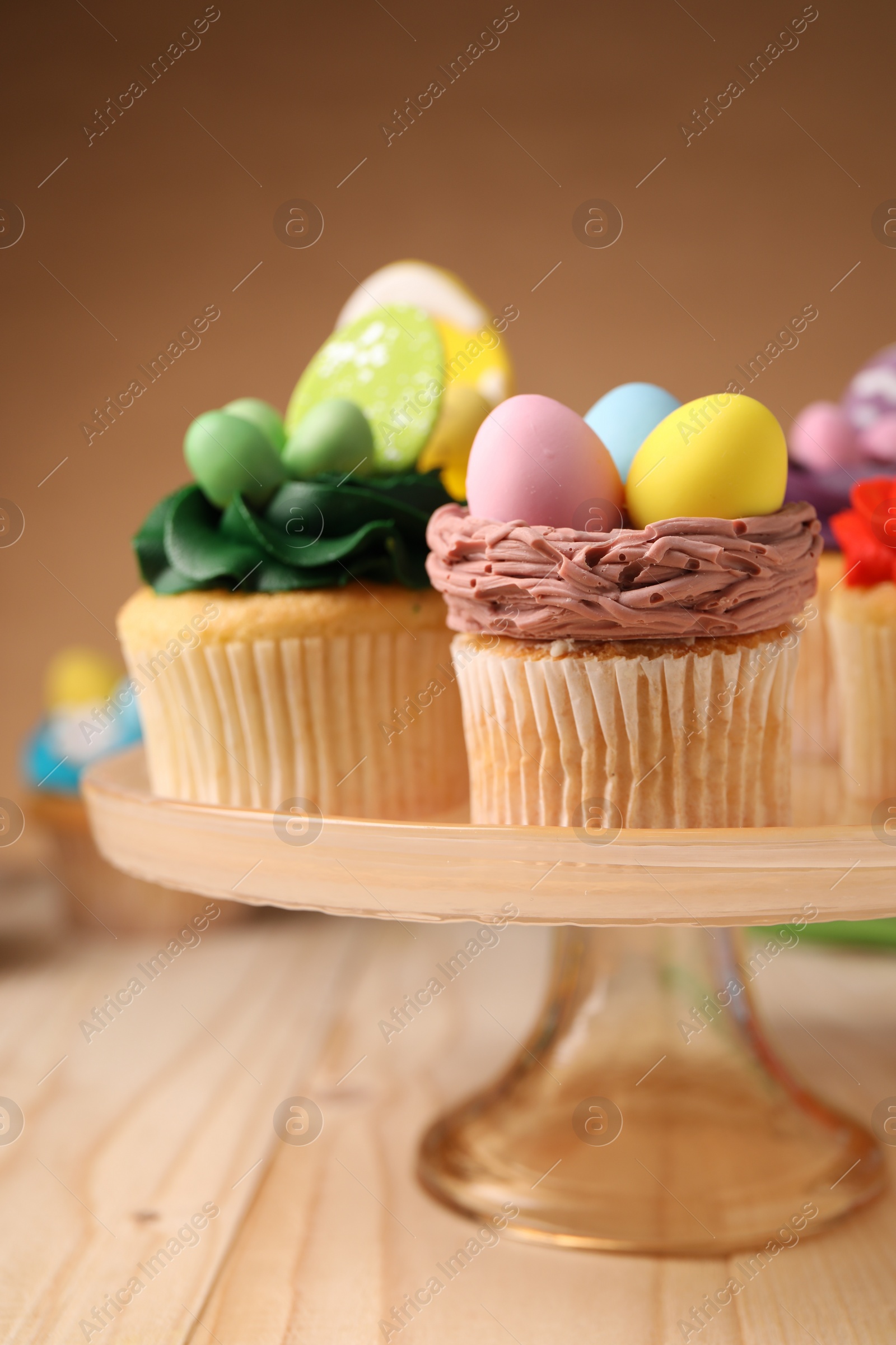 Photo of Tasty cupcakes with Easter decor on wooden table