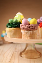 Tasty cupcakes with Easter decor on wooden table