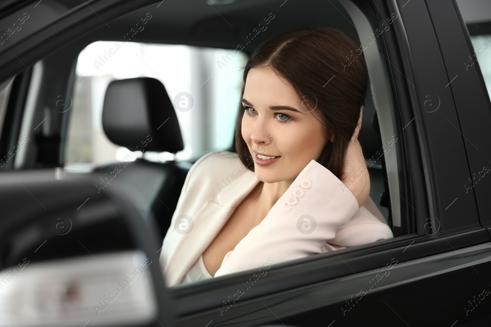 Photo of Young woman sitting in driver's seat of auto. Buying new car