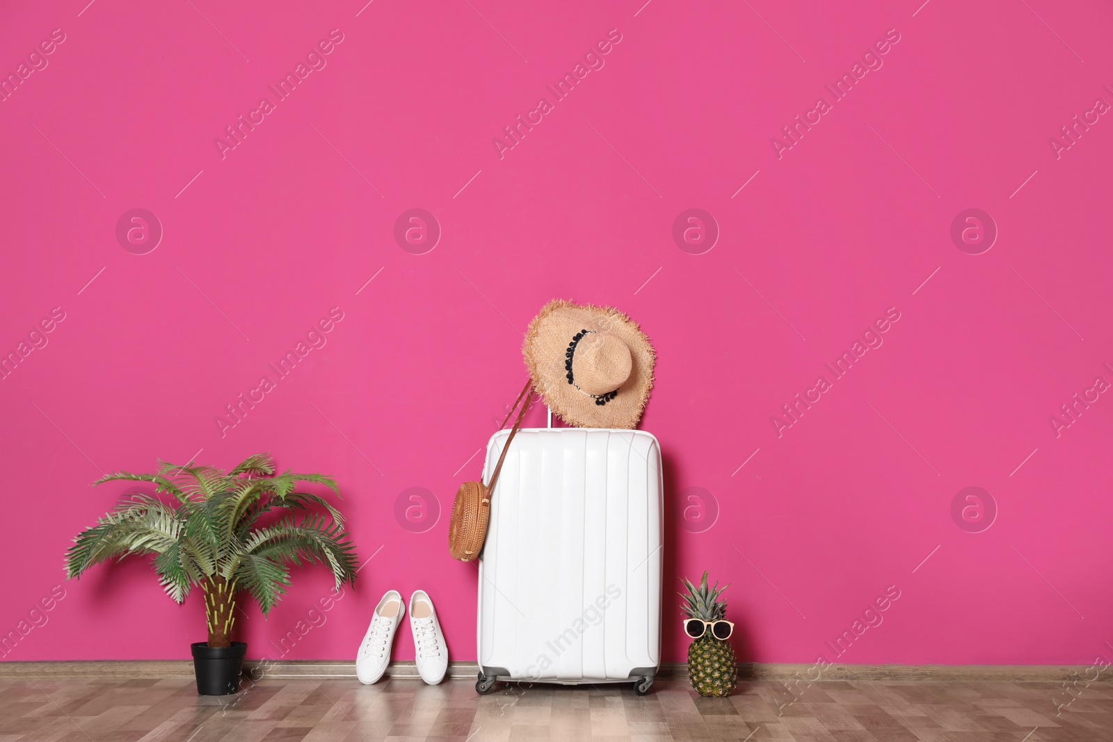 Photo of Large suitcase for travelling and beach items near color wall