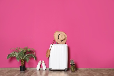 Photo of Large suitcase for travelling and beach items near color wall