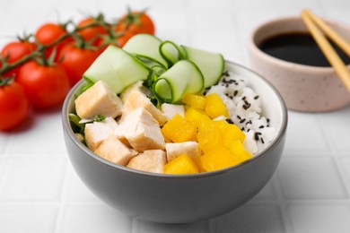 Delicious poke bowl with meat, rice and vegetables served on white table, closeup