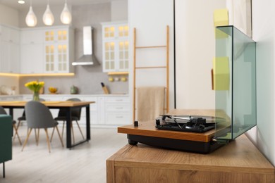 Photo of Spring interior. Vintage vinyl record player with disc on wooden surface in room, space for text