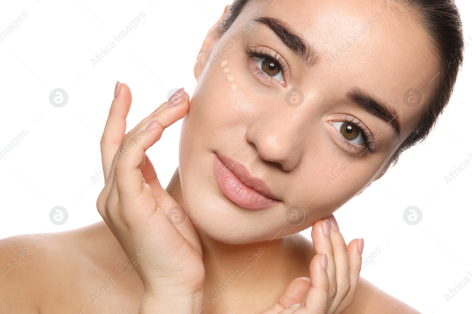 Photo of Portrait of young woman with liquid foundation on her face against white background