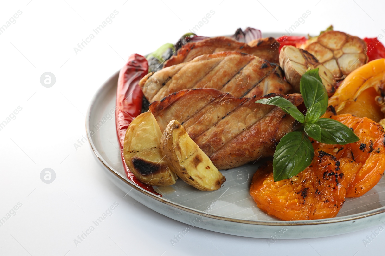 Photo of Plate with tasty grilled vegetables, meat and basil isolated on white